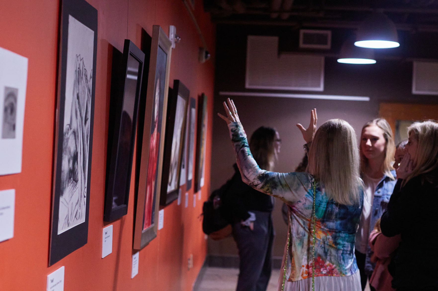 Women gesture at painting